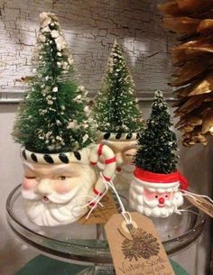 three small christmas trees in pots with santa's faces on them and a price tag hanging from the top