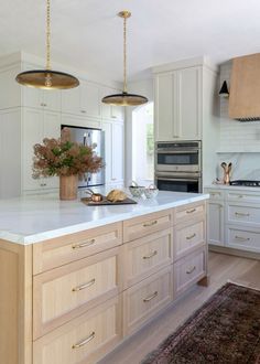 a large kitchen with white cabinets and an island