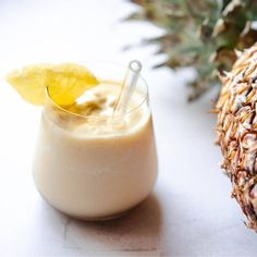 a drink in a glass next to a pineapple