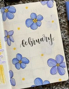 an open notebook with blue flowers and the word february written in cursive writing