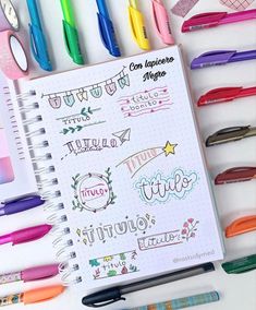 a notebook with some writing on it next to markers and pencils in different colors