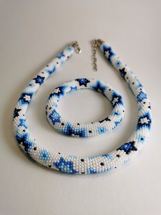 two pieces of beaded jewelry on a white surface