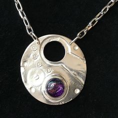 "Purple and silver together, a beautiful combination! This pendant is a nod back to our original Pocket Watch Pendants, starting in 2006.  We have always used .999 Fine Silver to create our classic DADDY'S WATCH ™️ Pocket Watch Pendants. All variations on this design come from my father's pocket watch. This pendant has plenty of presence, but is lightweight to wear. It has a 10mm PURPLE dichroic glass cabochon, accented with four 1mm WHITE cubic zirconias. The Purple Cabochon is set in a fine silver bezel.  The chain is a Sterling Silver Plated 7mm (links) drawn chain measuring 2 lengths of chain 12\" long on each side, making a 24\" chain. The silver plated Lobster clasp is a generous size, and of course you can attach it along the chain wherever you want.  Back is free formed and stamped Green Companies, Watch Pocket, Purple Gems, Purple And Silver, Dichroic Glass, Fine Silver, Gift For Women, Pocket Watch, Lobster Clasp