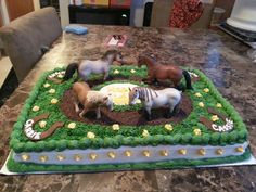 a birthday cake with horses on it sitting on a table