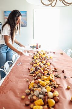 a woman standing over a table with food on it