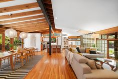 a living room filled with furniture next to a wooden floor covered in lots of windows