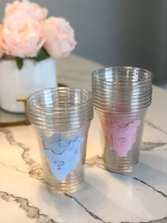 two shot glasses sitting on top of a marble table