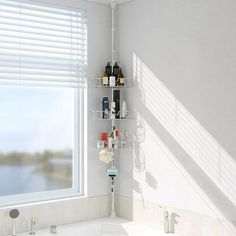 a bath room with a tub and a shelf next to a window in the corner