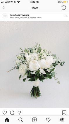 a bouquet of white flowers sitting on top of a table next to an instagram page