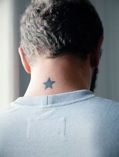 the back of a man's neck with a small star tattoo on his left side