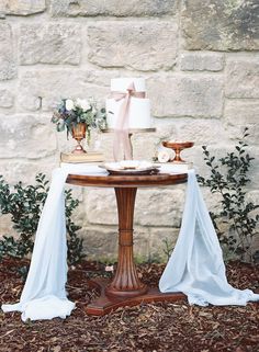 a table topped with a cake next to a wall