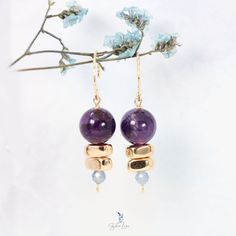 These unique natural stone beads dangle drop earrings feature a 12 mm purple Amethyst bead and two prayed gold color hematite beads with a blue faceted Kyanite stone drop at the end on solid 925 sterling silver textured ear wires with 18k gold plate. The eye pins are also gold plated 925 sterling silver. Add these unique Amethyst, Hematite, Kyanite natural stones dangle drop earrings to your everyday fine jewelry collection or as a gift for your loved one. Materials: 925 sterling silver, amethyst, kyanite, hematite Finish: gold platedDimensions: 1.74 x 0.45 in Jewelry Care: See more information about how to care for your jewelry here. Shipping Policy: Orders will be shipped within 1-3 business days. Economy shipping will take 7-14 days to arrive and standard shipping is 1- 4 days for U.S. Purple Gemstone Bead Dangle Earrings, Purple Gemstone Beads Dangle Earrings, Purple Dangle Earrings With Gemstone Beads, Purple Gemstone Round Bead Earrings, Spiritual Gemstone Earrings With Round Beads, Purple Gemstone Earrings With Round Beads, Gold Spiritual Earrings With Gemstone Beads, Spiritual Amethyst Earrings With Natural Stones, Healing Amethyst Earrings With Natural Stones