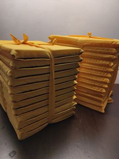 several stacks of folded yellow paper sitting on top of a wooden table