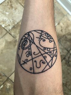 a man's arm with a tattoo on it that has an image of a wheel