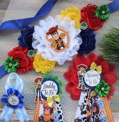 three ribbons and two badges are on display for the children's first birthday party