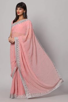 Isn't she pretty in pink in our Aaliya Dusty Rose Silver Embroidered Mirror Work One Minute Saree? This shining Pink Georgette saree isn't just a garment; it's a masterpiece. Each intricate stitch and shimmering mirror detail tell a story of craftsmanship and creativity. With a blouse crafted from the same ethereal fabric, featuring half sleeves and a graceful v-neck, it's a symphony of style. About this Product Saree: Saree Type: Ready to wear, Pre-stitched, Pre-draped Saree Saree Color: Pink S Pink Chinon Pre-draped Saree For Navratri, Pink Embroidered Pre-draped Saree For Reception, Pink Pre-draped Chinon Saree For Navratri, Bollywood Style Pink Embroidered Pre-draped Saree, Festive Pink Saree With Sheer Dupatta, Bollywood Style Embroidered Pink Pre-draped Saree, Designer Wear Pink Embroidered Pre-draped Saree, Designer Pink Embroidered Pre-draped Saree, Designer Embroidered Pink Pre-draped Saree