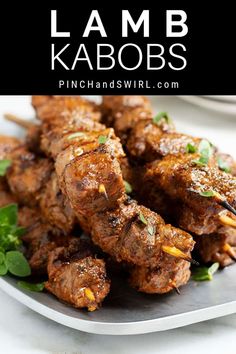 lamb kabobs on a plate with garnishes and parsley in the background