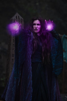 a woman with long hair and purple lights in her hands