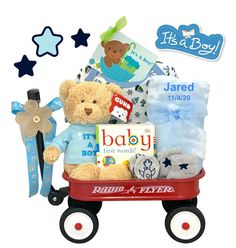 a teddy bear sitting on top of a wagon filled with baby items