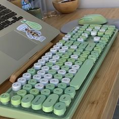 a computer keyboard sitting on top of a wooden desk next to a laptop and mouse