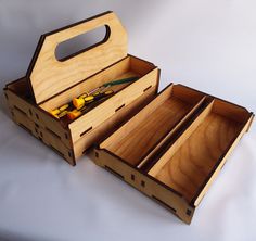 an open wooden box with tools inside on a white surface