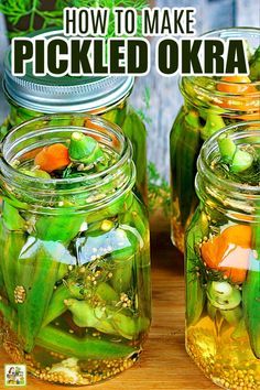 two jars filled with pickled okra on top of a wooden table