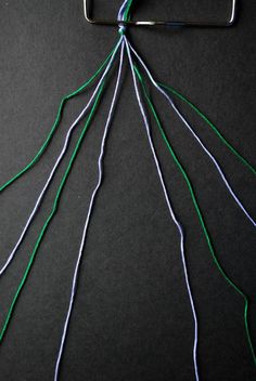 a piece of wire with green and blue wires attached to it on a black surface