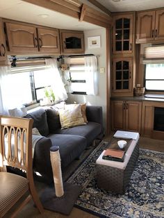 a living room filled with furniture next to a kitchen and dining area in a mobile home