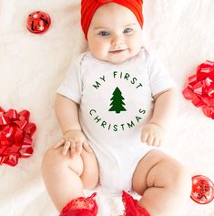 Celebrate your baby's first Christmas with our adorable My First Christmas White Bodysuit, designed to capture the joy and excitement of this special milestone. Key Features: Design: Sweet and charming "My First Christmas" graphic, perfect for creating lasting memories and capturing precious moments. Material: Made from soft and breathable cotton to ensure comfort and coziness for your baby's delicate skin. Fit: Features expandable shoulders and snap closures for easy dressing and diaper changes Christmas Baby Outfits, Wedding Bottle Labels, Birthday Wine Glasses, Christmas Wine Glasses, Christmas Baby Announcement, Christmas Bodysuit, Classic Christmas Movies, Baby's 1st Christmas, Meet Santa