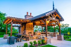 an outdoor kitchen and dining area in a backyard