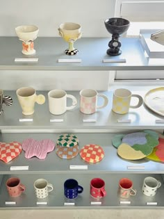 there are many cups and plates on display