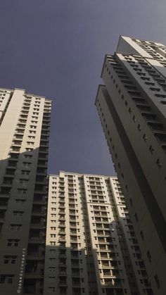 two tall buildings with balconies against a blue sky