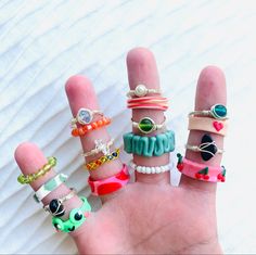 a hand with five different colored rings on it's fingers and one is holding the other