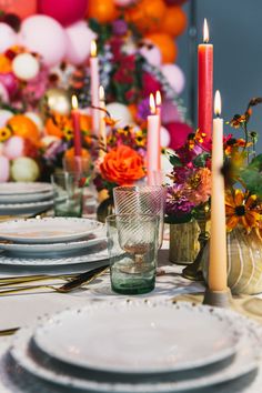 the table is set with plates and candles