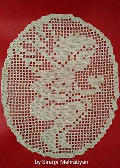 a crocheted doily is shown on a red surface