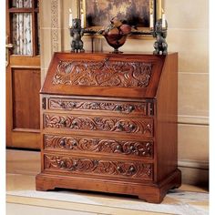 an ornately carved wooden chest of drawers in a room with a painting on the wall