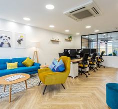 an office with blue couches and yellow chairs