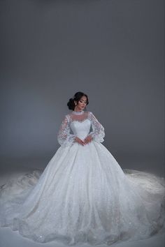 a woman in a white wedding dress posing for the camera with her hands on her hips