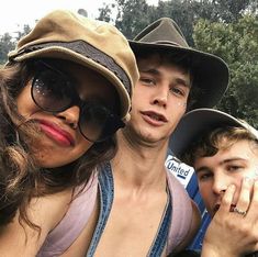 two people with hats and sunglasses posing for the camera