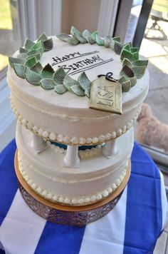 a three tiered cake sitting on top of a blue and white striped table cloth