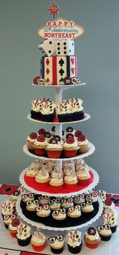 a tiered cake with cupcakes on it