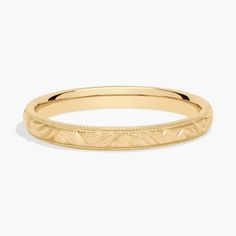 a yellow gold wedding band with engraved details