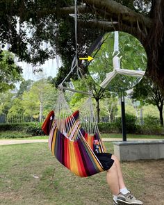 a person sitting in a hammock hanging from a tree