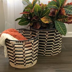 two woven baskets with plants in them on the floor