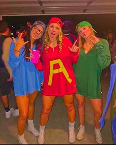 three women in costumes posing for the camera with one holding up her peace sign and the other pointing