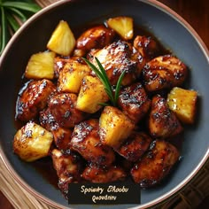 a bowl filled with pineapple chicken on top of a wooden table