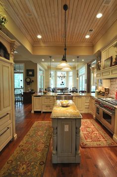 a large kitchen with an island in the middle and lots of cabinets on both sides