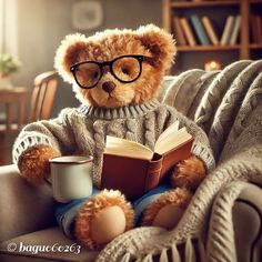 a teddy bear sitting on a couch with a book and coffee cup in his lap