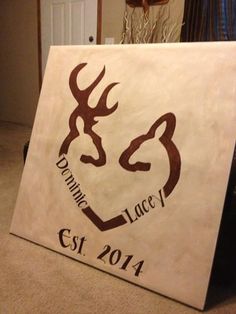 a sign that is sitting on the floor in front of a door with a deer's head painted on it