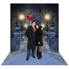 a man and woman standing in front of a gate with a heart shaped balloon on it